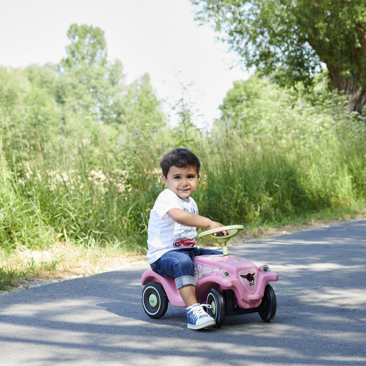 Rozā Bobby Car ar ziedu rakstu un tauri uz stūres
