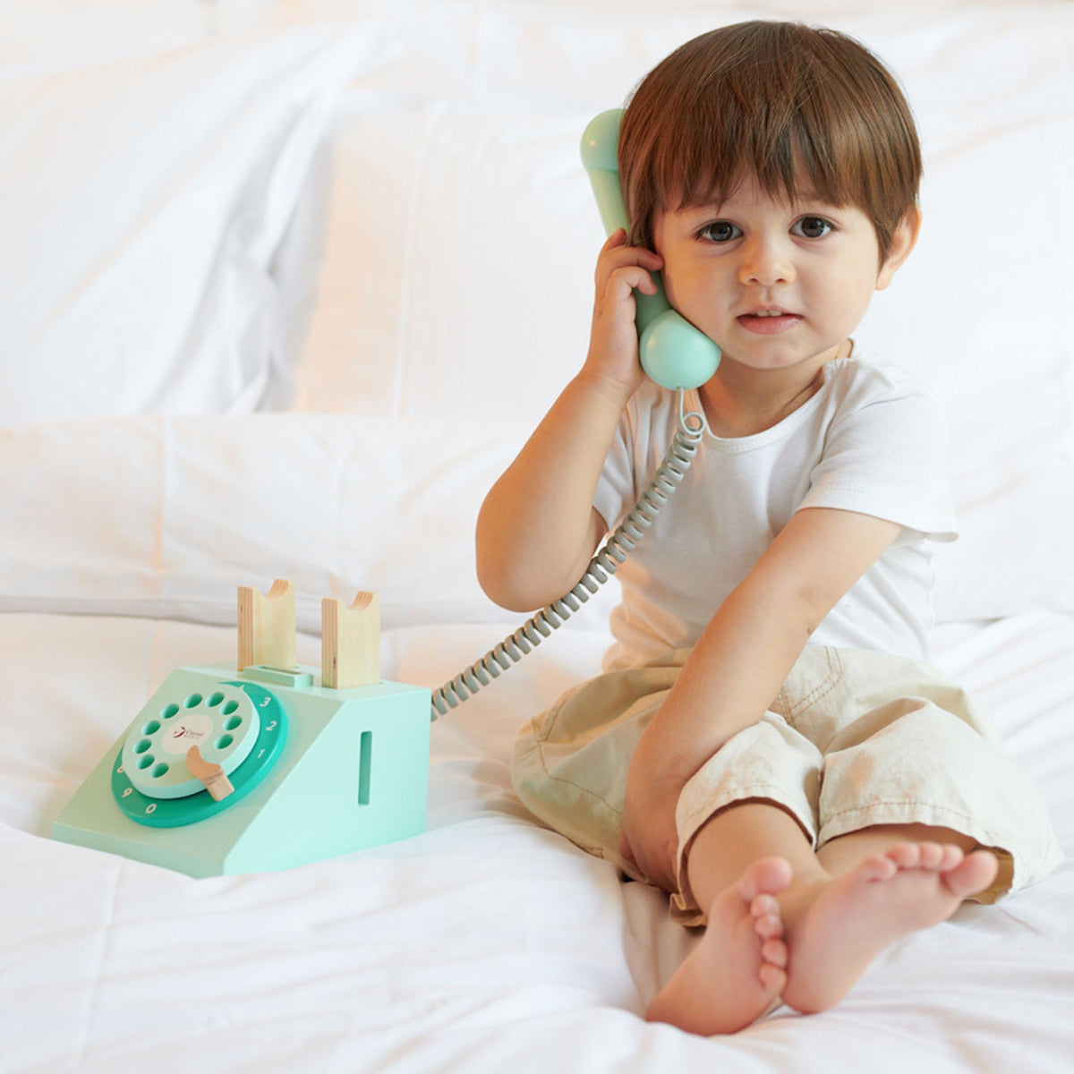 Child talking on the vintage wooden toy phone
