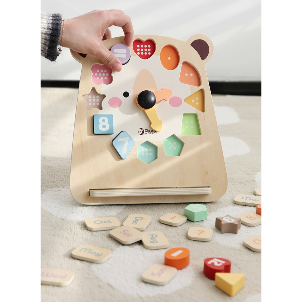 Child setting the hands on the wooden teddy clock