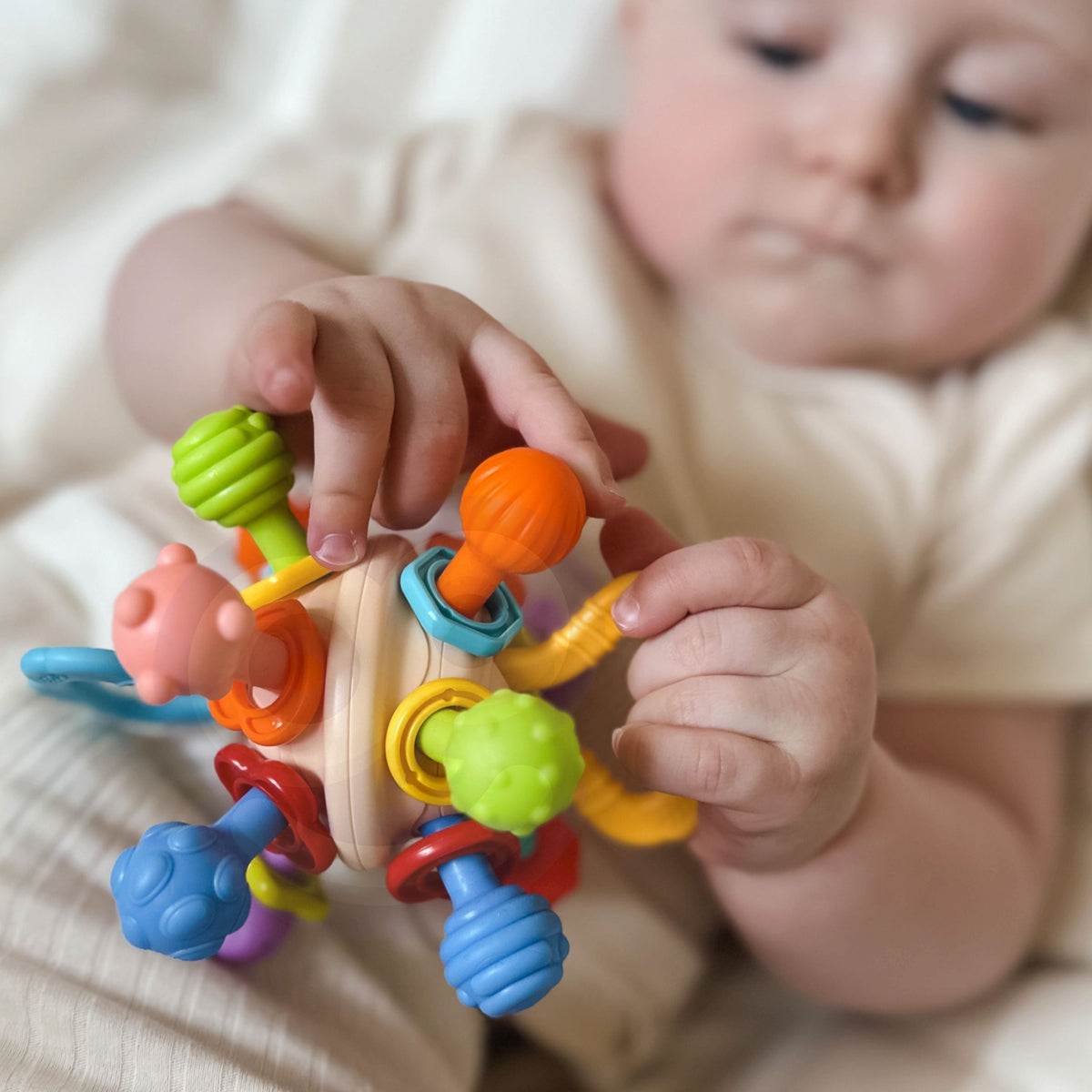 Colourful ball rattle with rotating rings that click softly