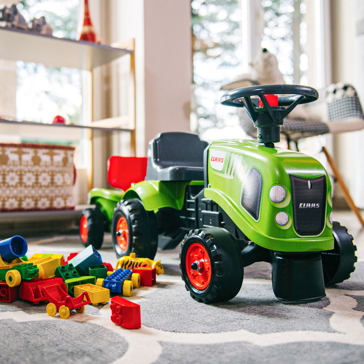Toddler riding the Baby Claas tractor in the garden
