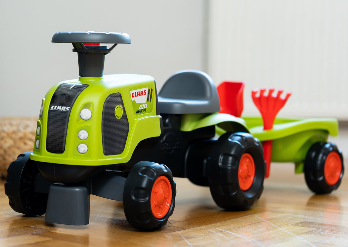 Claas traktors ar lāpstiņu un grābekli piekabē