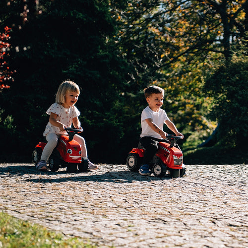Red ride-on tractor with mini trailer, shovel and rake