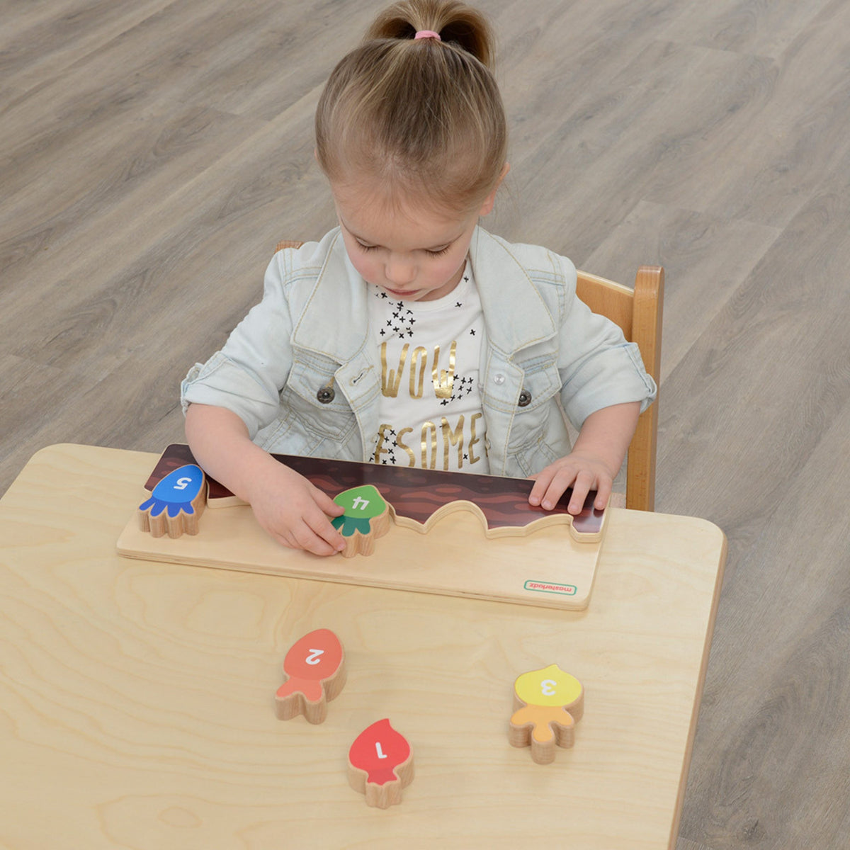 Toddler planting wooden vegetables and counting