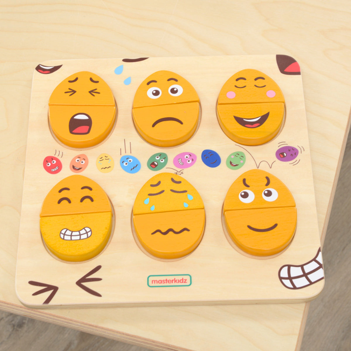Board with wooden eggs showing happy, sad and surprised faces