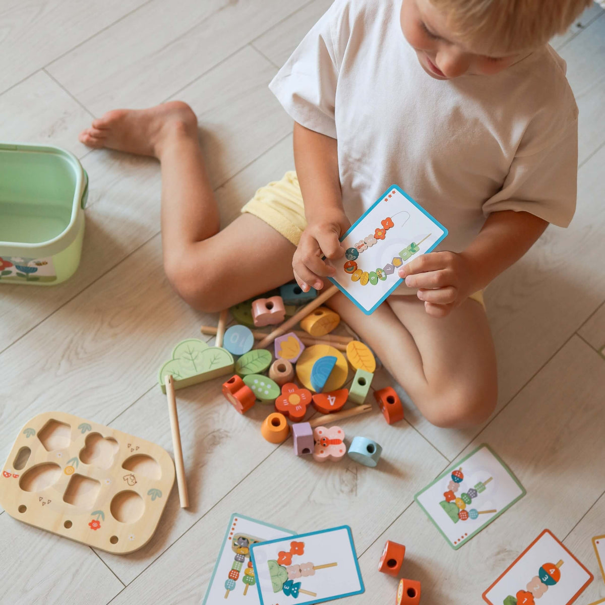 Wooden threading game with colourful garden pieces