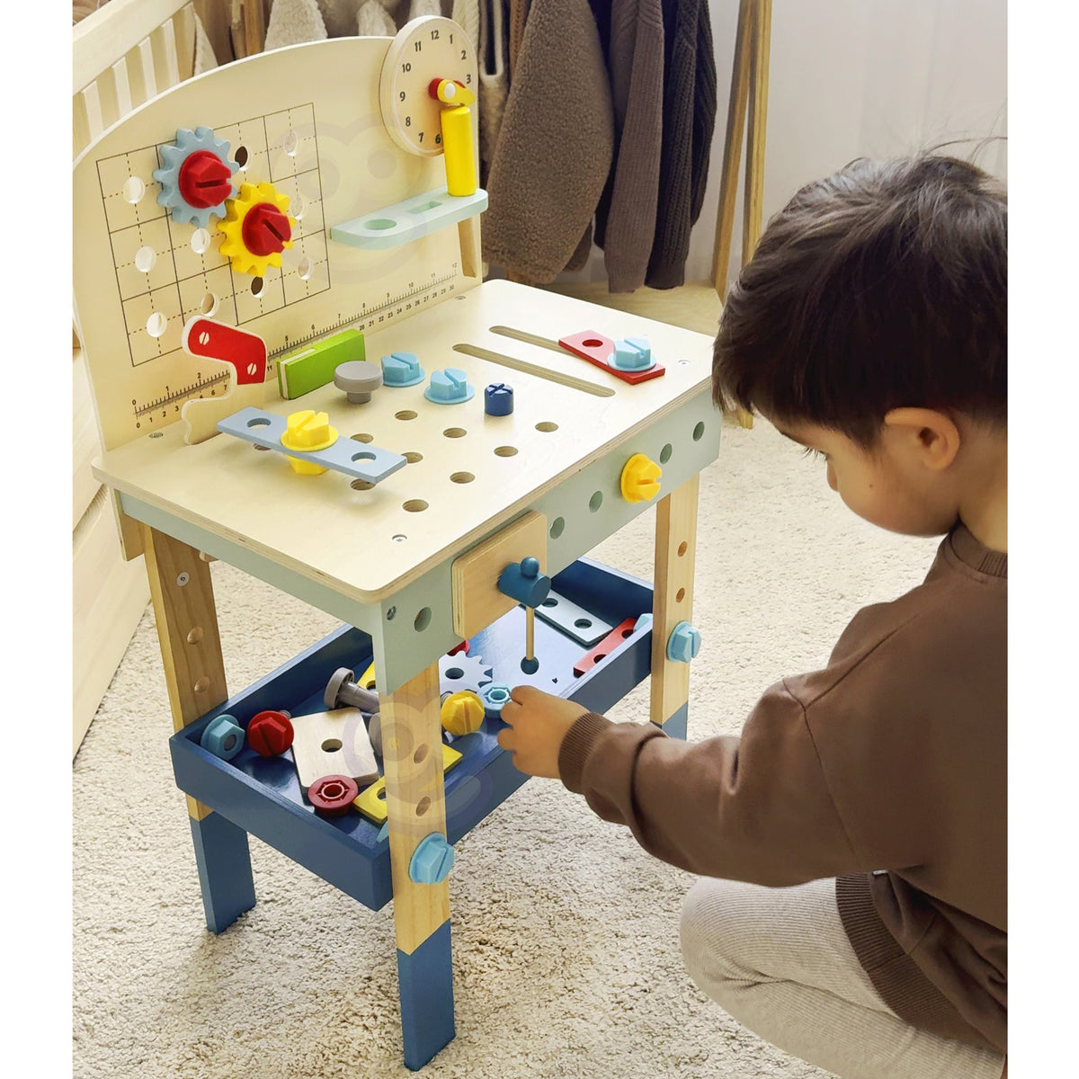 Child screwing a bolt on the wooden workbench