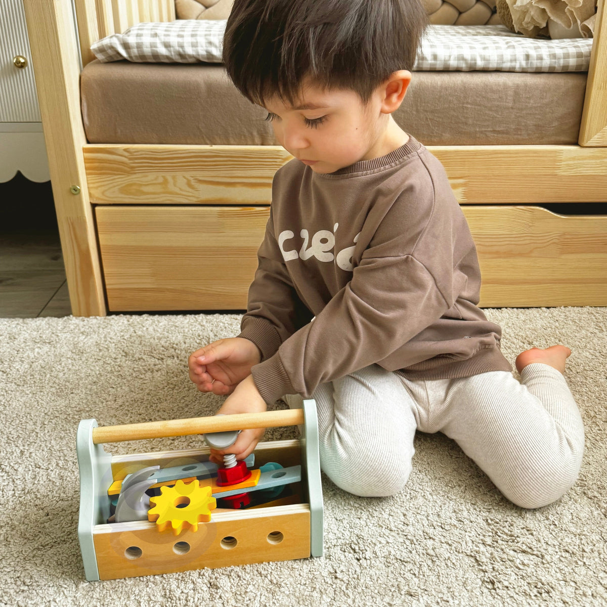 Child building with boards and screws from the toolbox