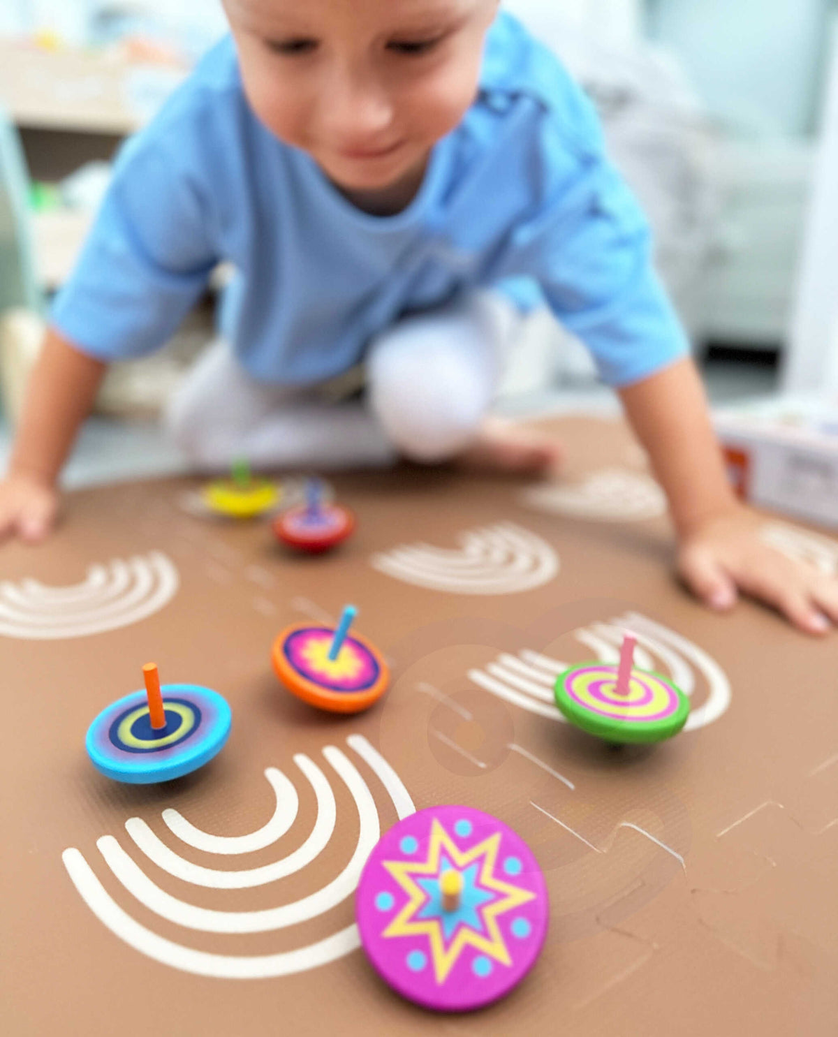 Child spinning the wooden top on a smooth table