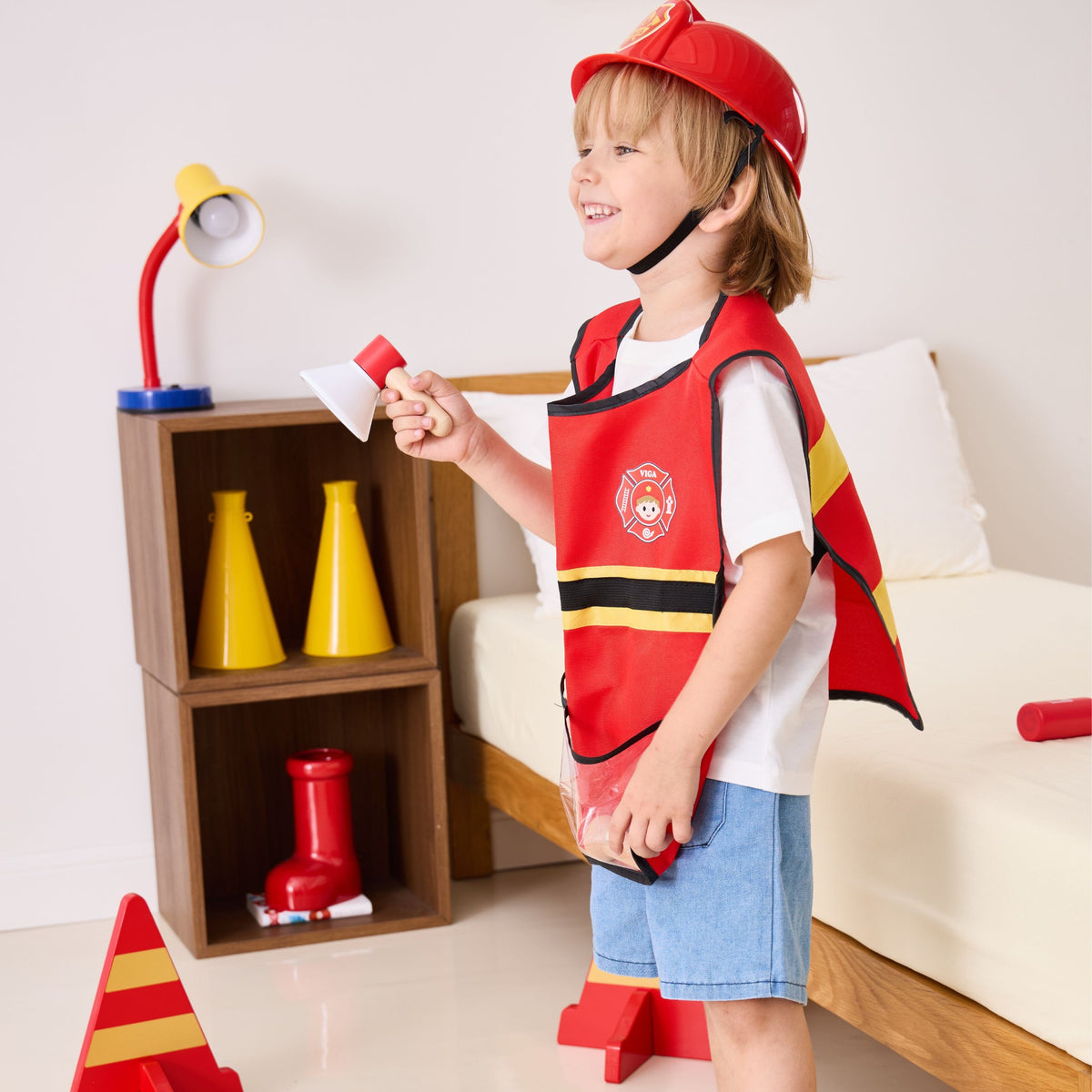 Child dressed as a firefighter with wooden tools