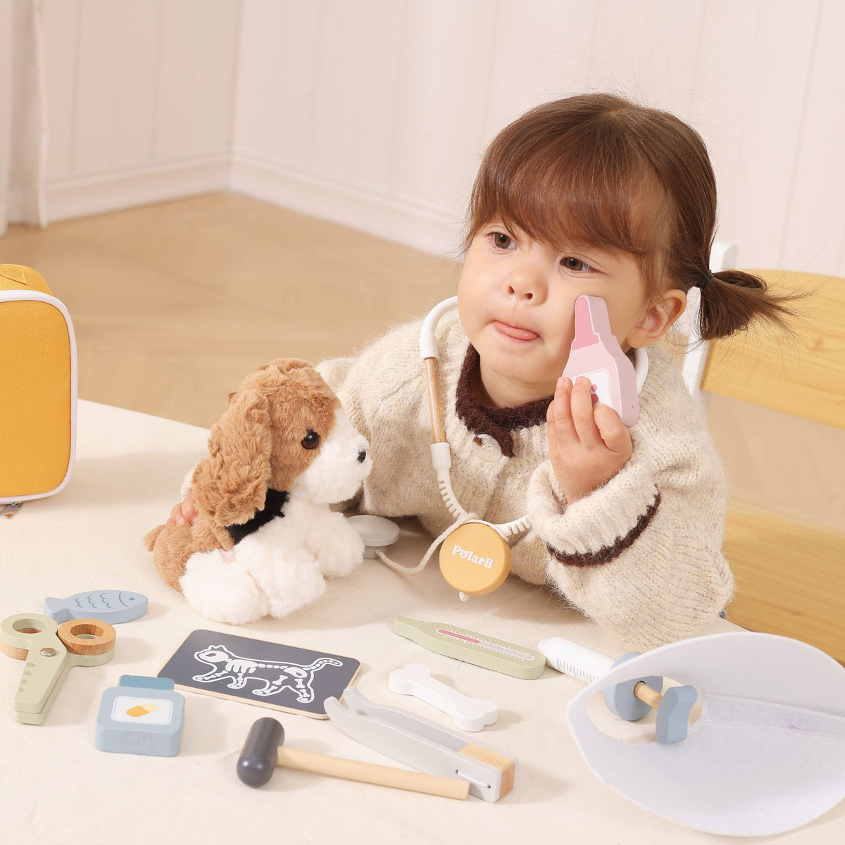 Child treating a plush dog with the vet kit