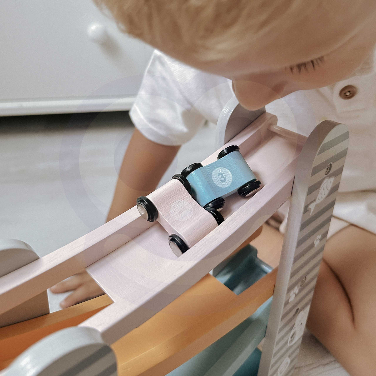 Mazulis palaiž mašīnas pa koka slidkalniņu