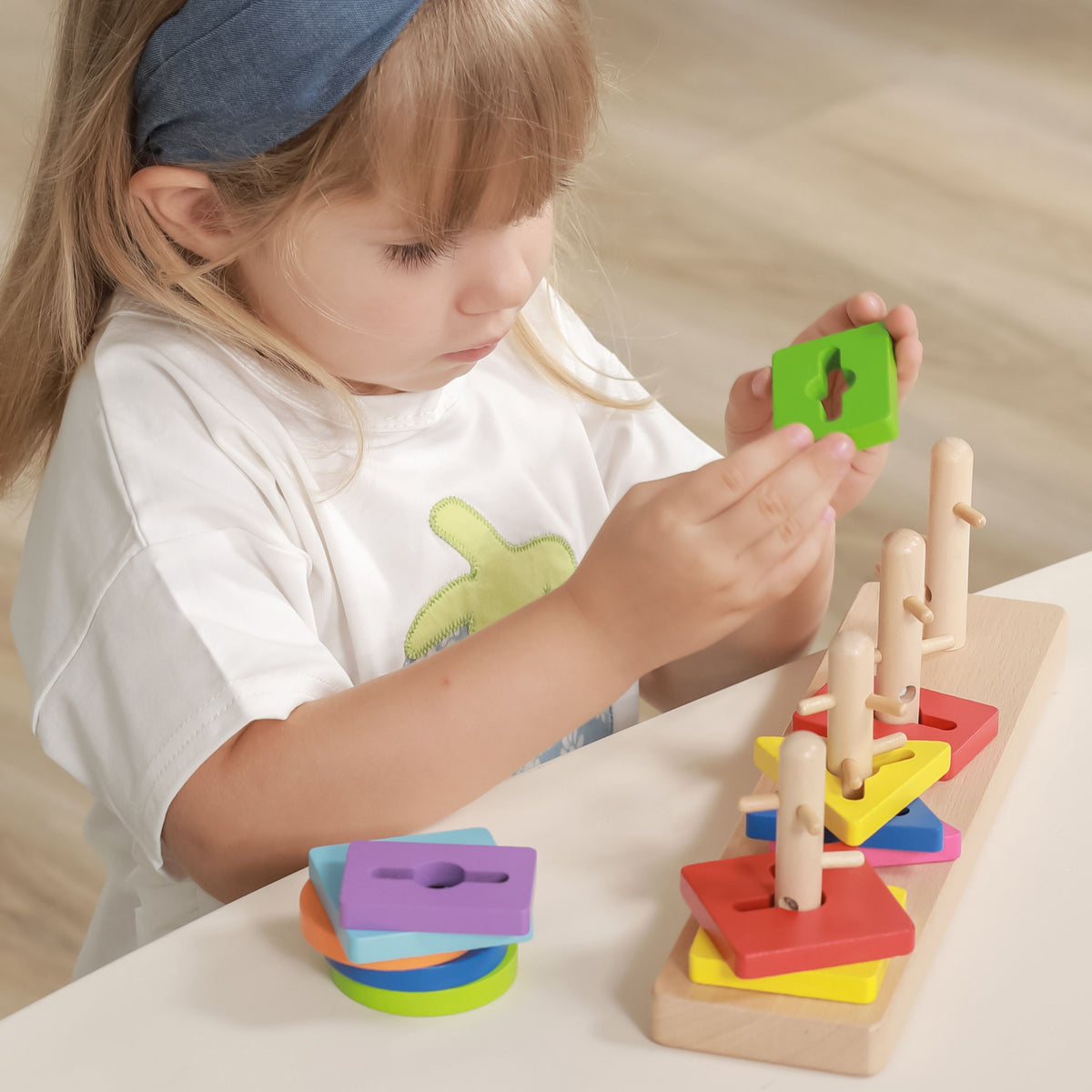 Coloured geometric blocks on five shaped pegs