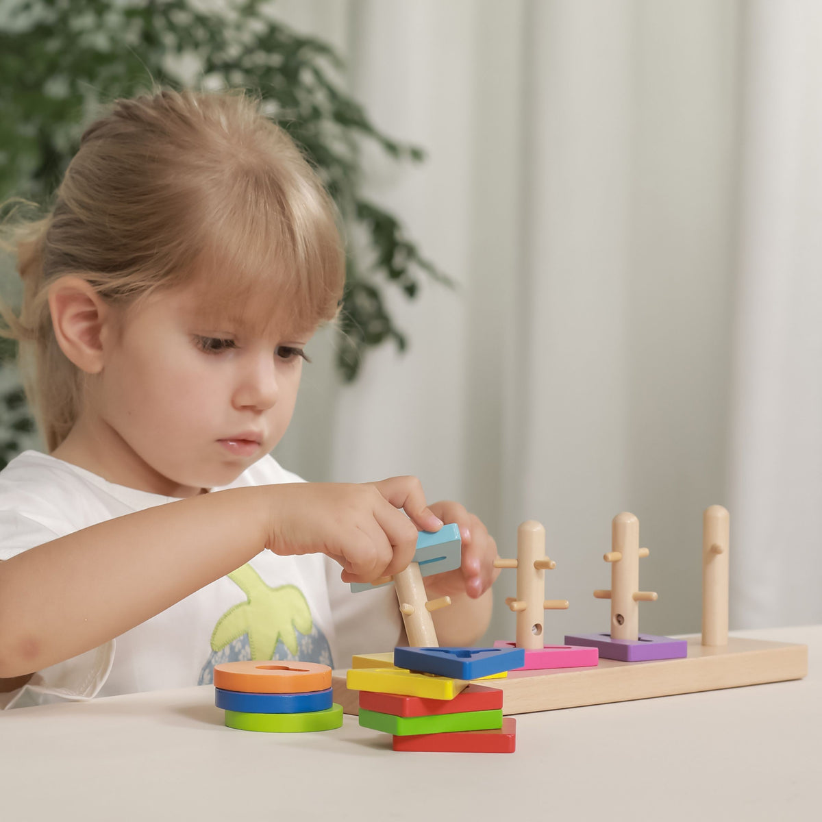 Toddler fitting a block onto the matching peg