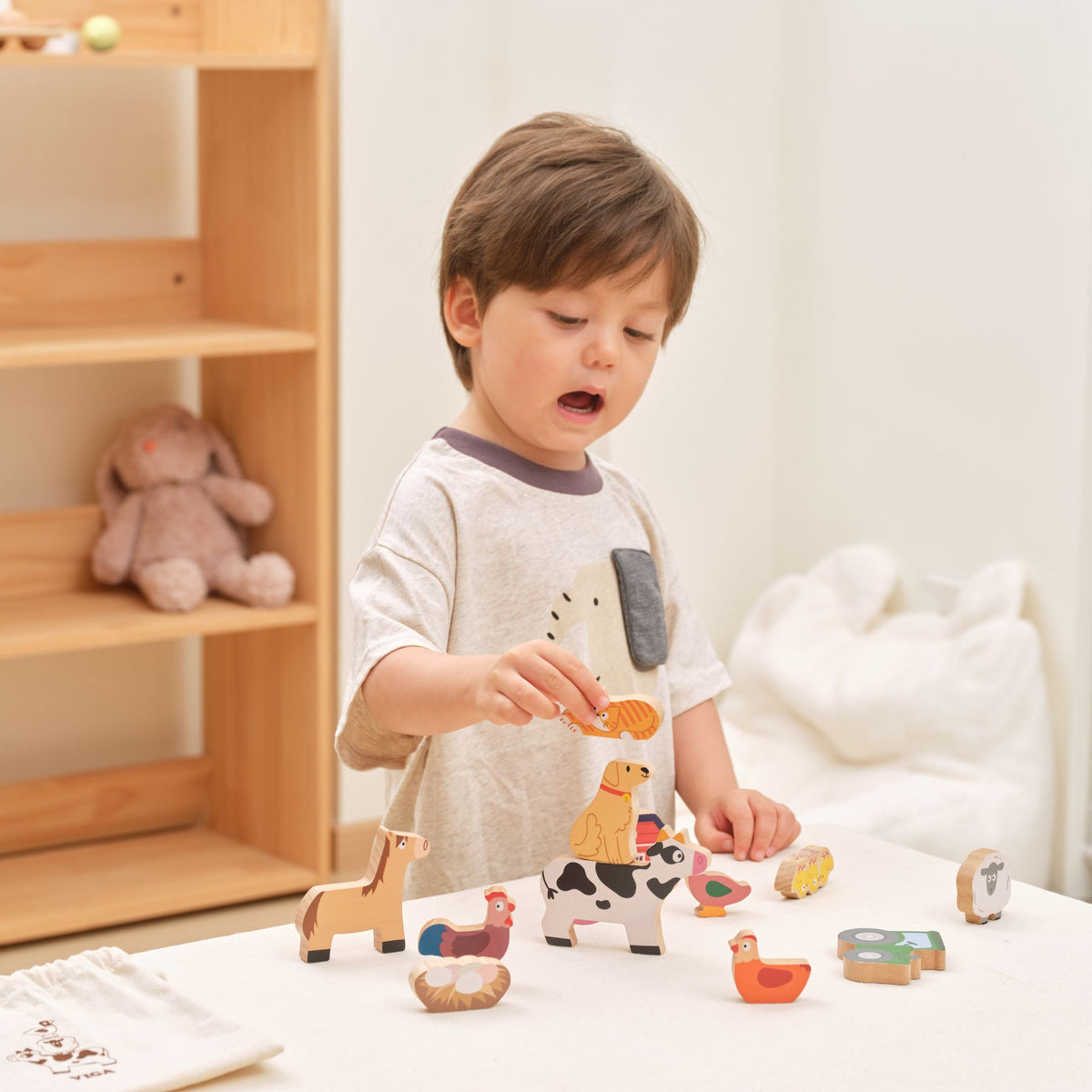 Wooden animal figures and a cotton storage bag