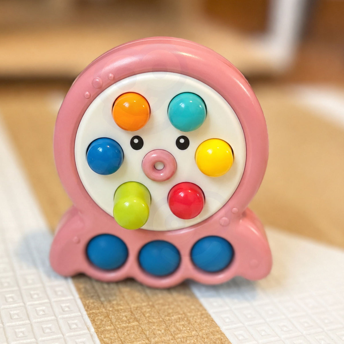 Toddler poking a mole back down on the pink octopus