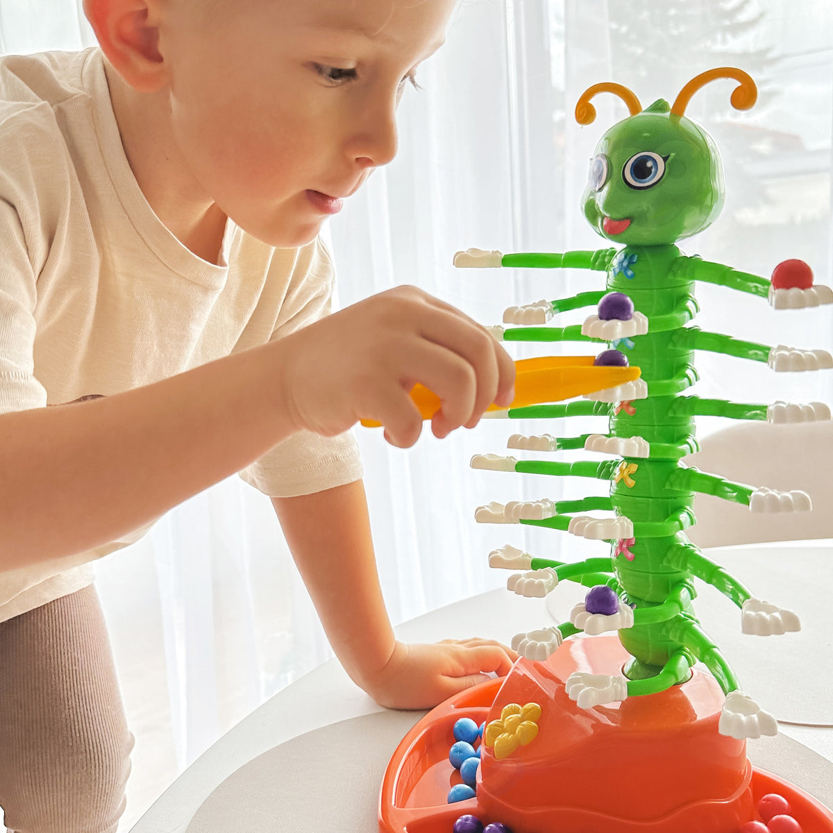 Caterpillar game tweezers and balls in four colours
