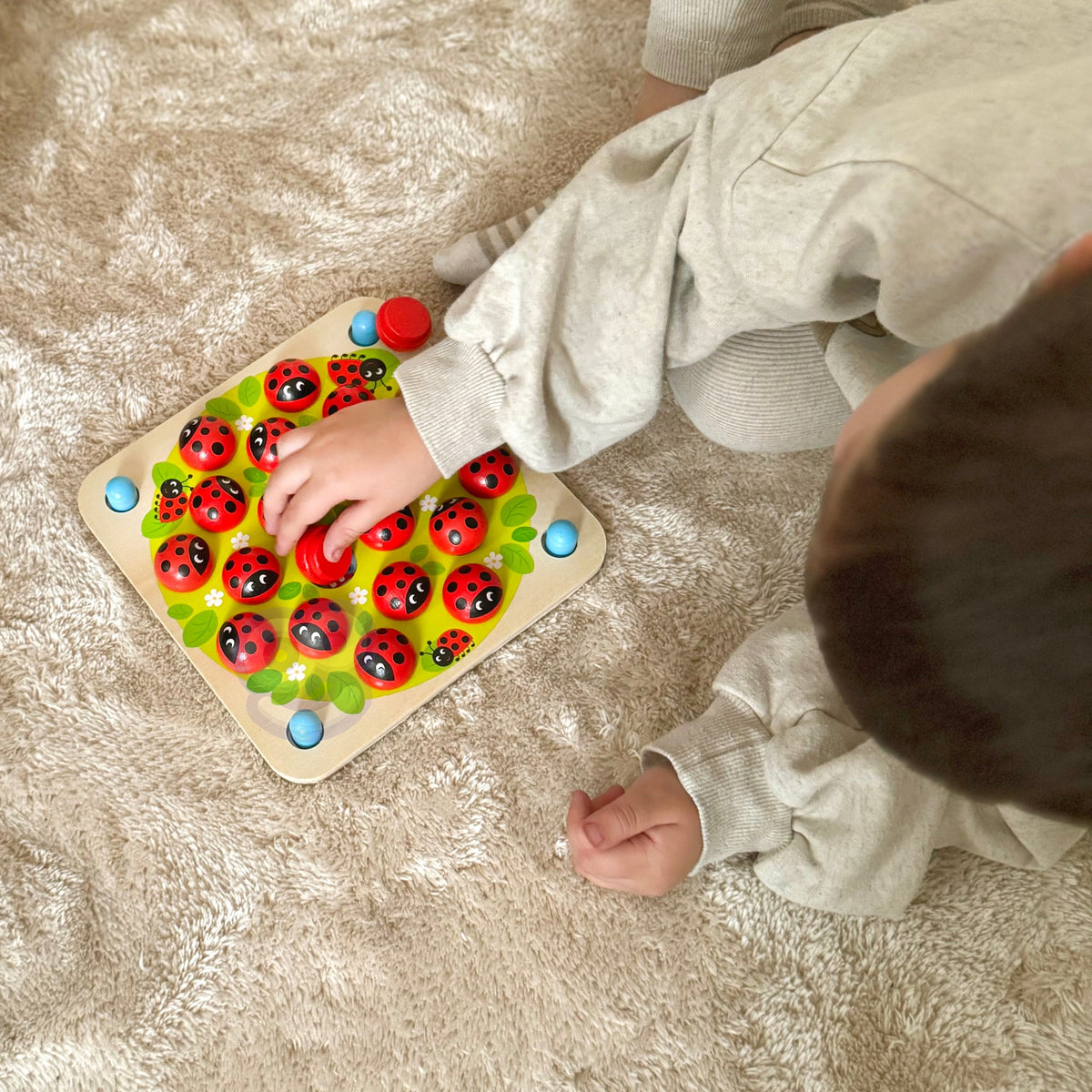 Child finding matching pairs on the ladybug board