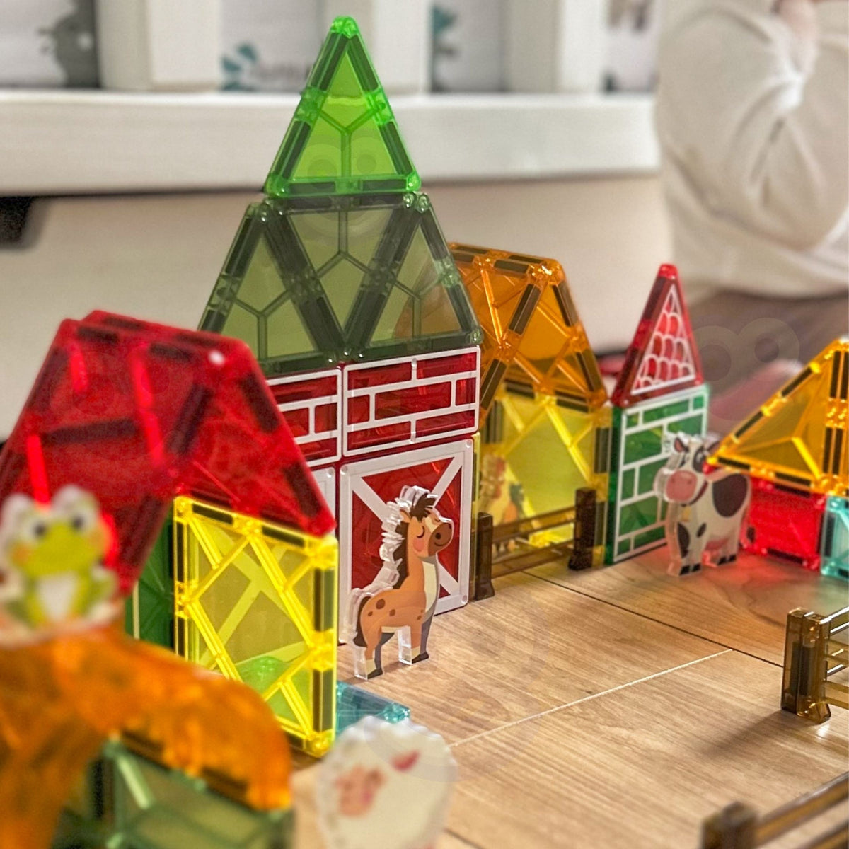 Child building a farm from magnetic tiles