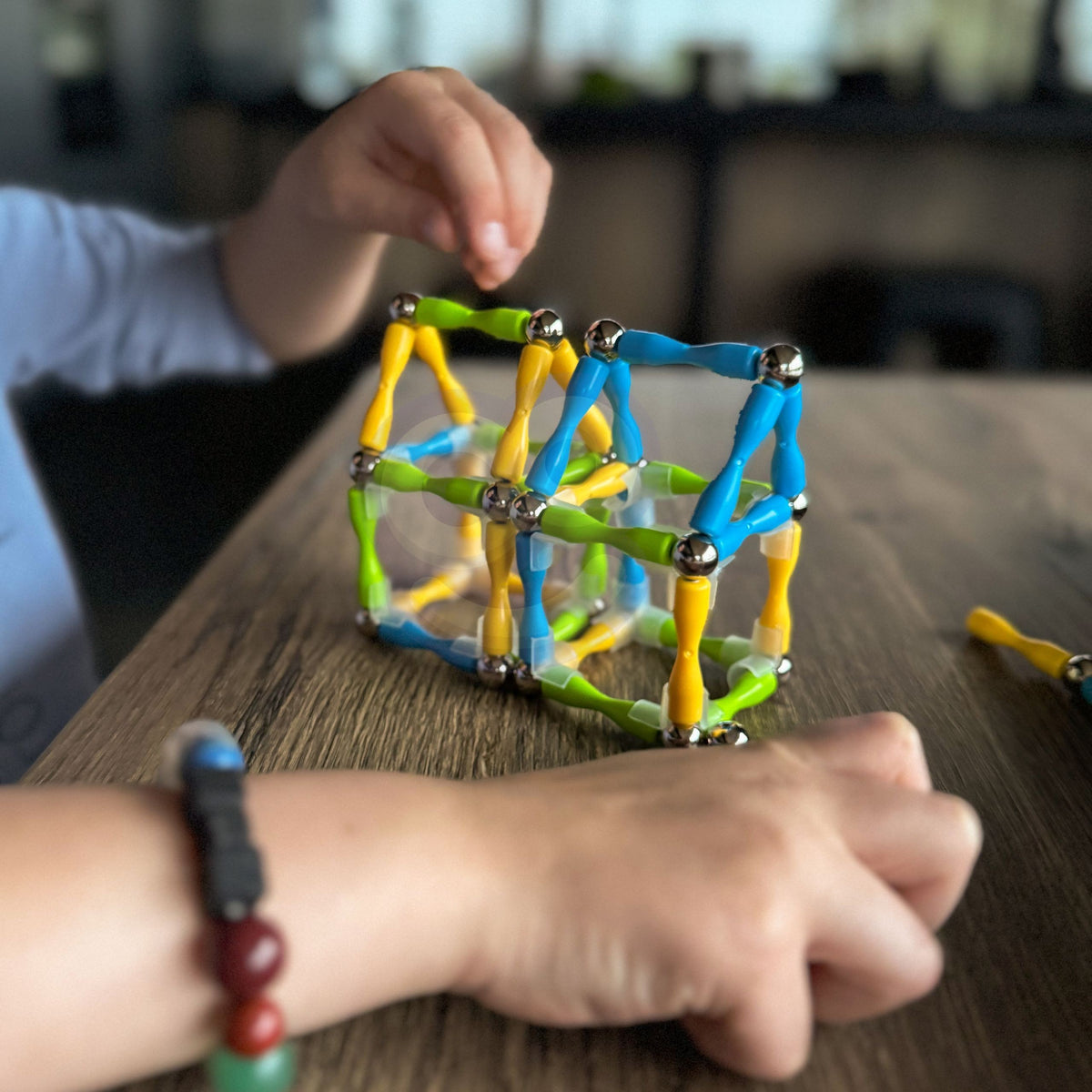 Blue, yellow and orange magnetic rods with metal balls