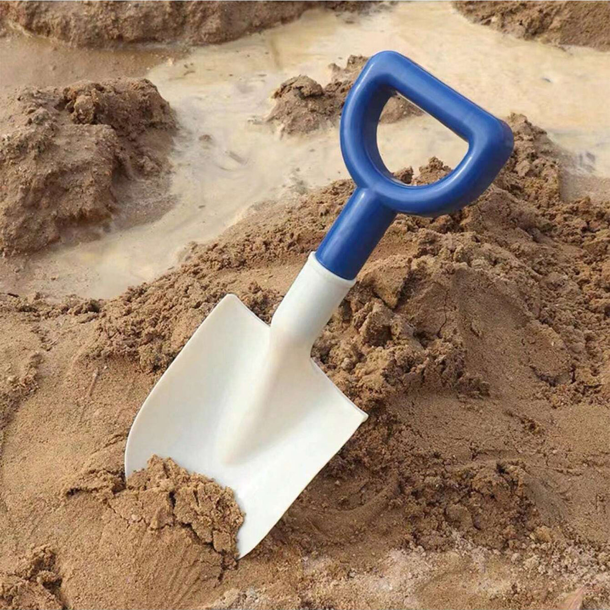 Child digging in the sandpit with the white shovel